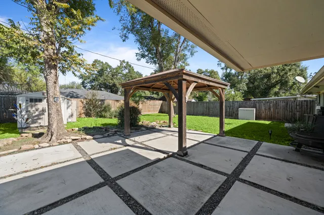 a view of a patio with a table chairs and a backyard