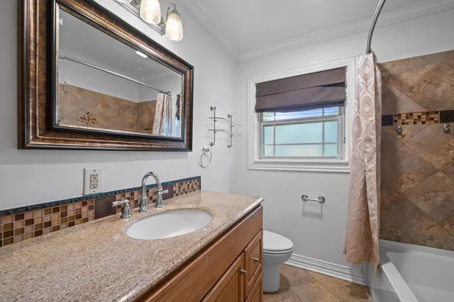 a bathroom with a granite countertop toilet a sink and mirror