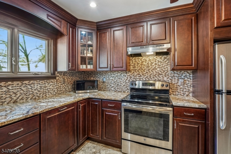 27 Espy Road, Unit A7 Caldwell, NJ 07006 - Photo 8 of 29 a kitchen with granite countertop cabinets stainless steel appliances and a counter space