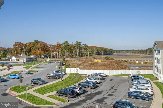 a view of a lake with lawn chairs and a barbeque