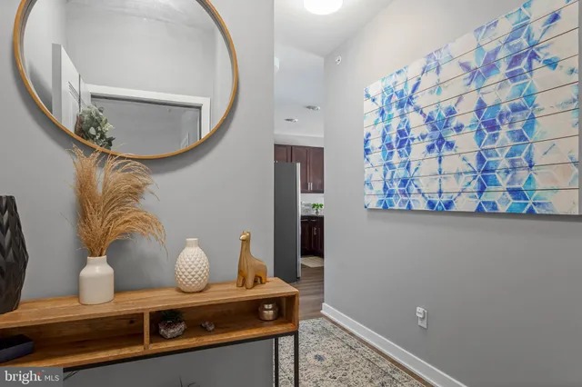 a kitchen with granite countertop stainless steel appliances a table chairs refrigerator and microwave