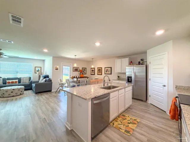 a kitchen with stainless steel appliances a sink and a refrigerator