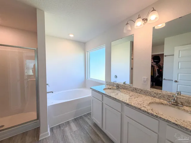 a bathroom with a granite countertop sink a mirror and a bathtub