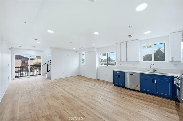 a kitchen with stainless steel appliances granite countertop a stove a sink dishwasher a refrigerator and a sink