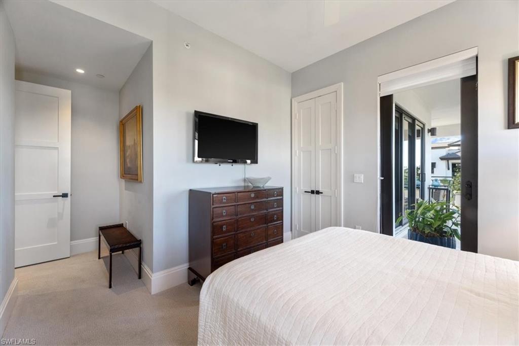 1035 3rd Avenue South, Unit 401 Naples, FL 34102 - Photo 19 of 43 a bedroom with a bed and a flat screen tv