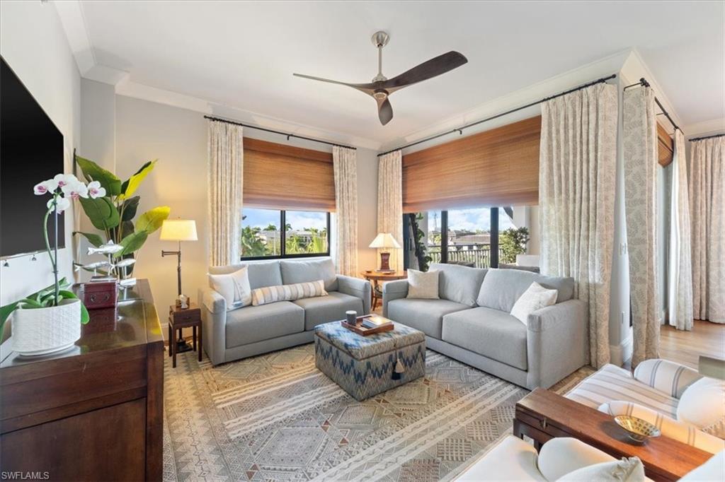 1035 3rd Avenue South, Unit 401 Naples, FL 34102 - Photo 5 of 43 a living room with furniture a chandelier and a large window