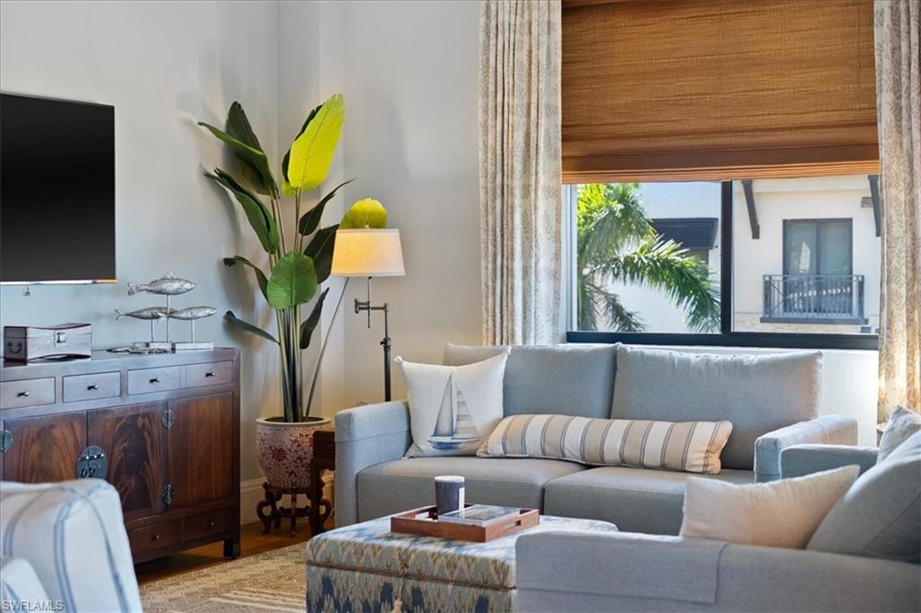 1035 3rd Avenue South, Unit 401 Naples, FL 34102 - Photo 6 of 43 a living room with furniture a flat screen tv and a potted plant