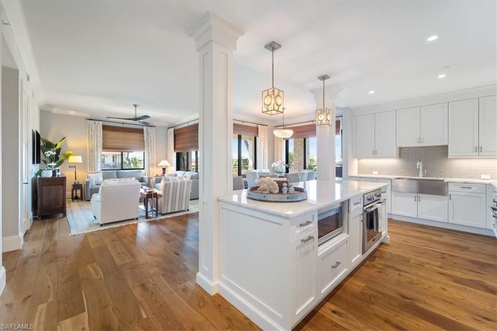 1035 3rd Avenue South, Unit 401 Naples, FL 34102 - Photo 7 of 43 a open kitchen with stainless steel appliances granite countertop a stove oven and a chandelier