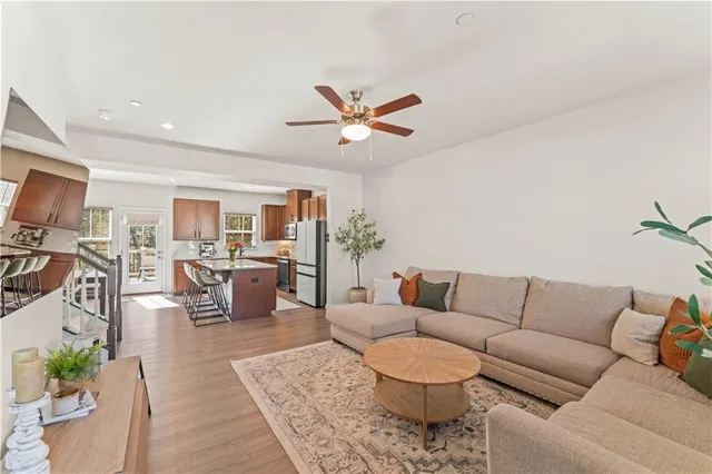 a living room with furniture kitchen view and a chandelier