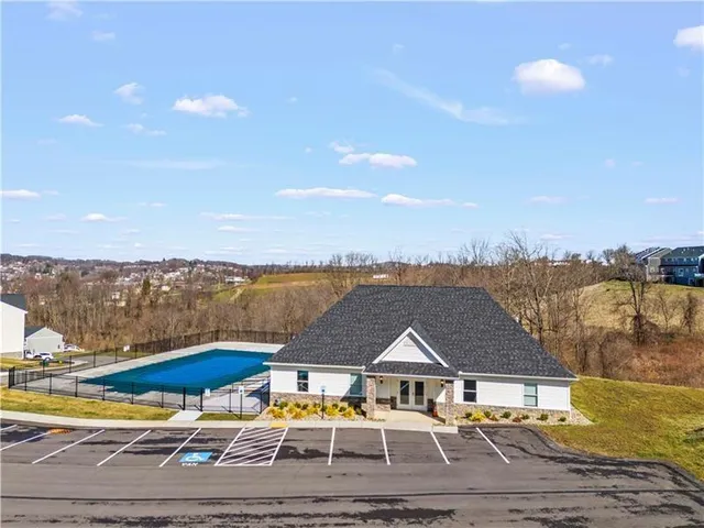 a aerial view of a house with pool and lake view
