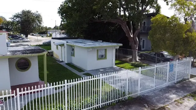a view of a house with backyard and trees