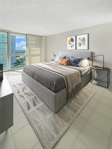 a spacious bedroom with a bed and glass window