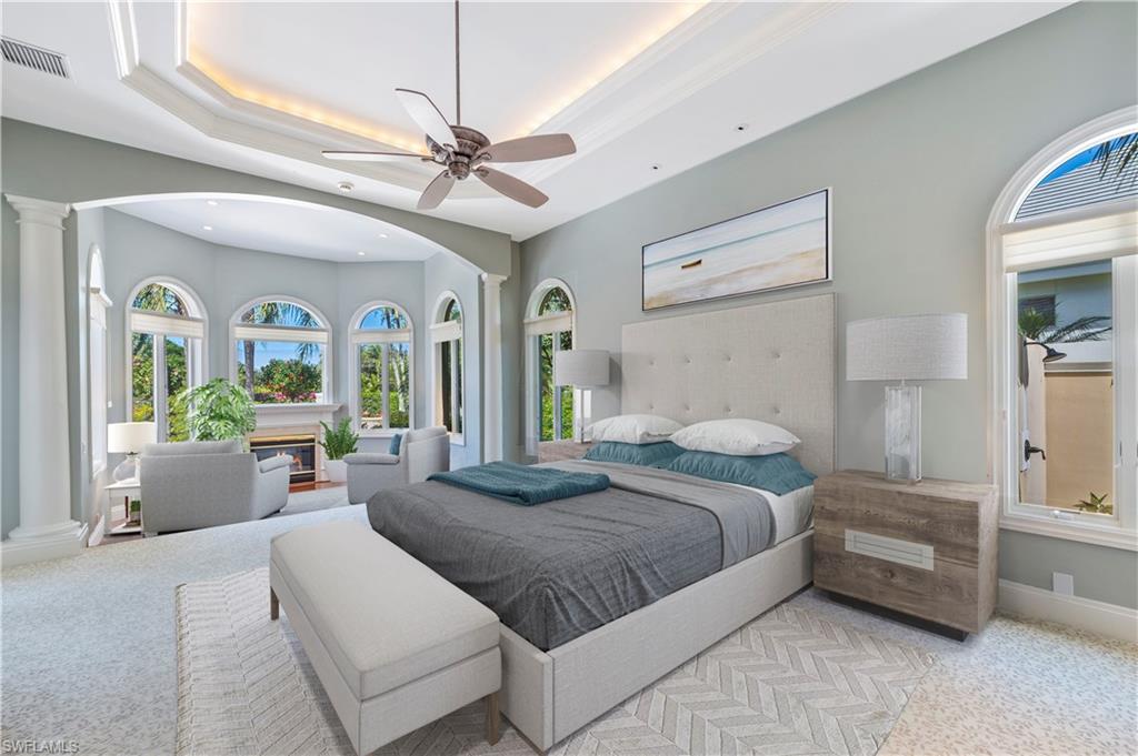 6963 Verde Way Naples, FL 34108 - Photo 16 of 31 a spacious bedroom with a large bed and a chandelier