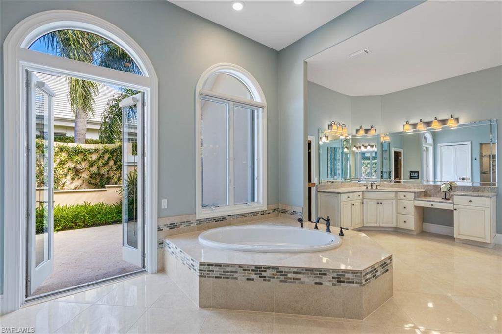 6963 Verde Way Naples, FL 34108 - Photo 19 of 31 a living room with a large window and a table