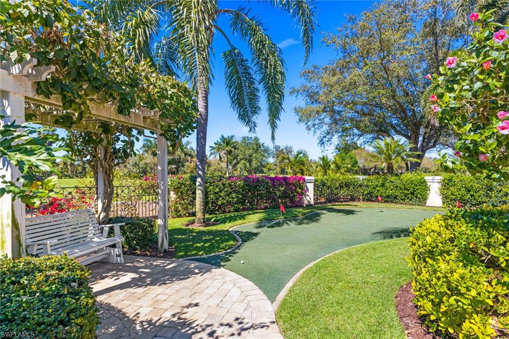 6963 Verde Way Naples, FL 34108 - Photo 21 of 31 a backyard of a house with a swing chair and entertaining space
