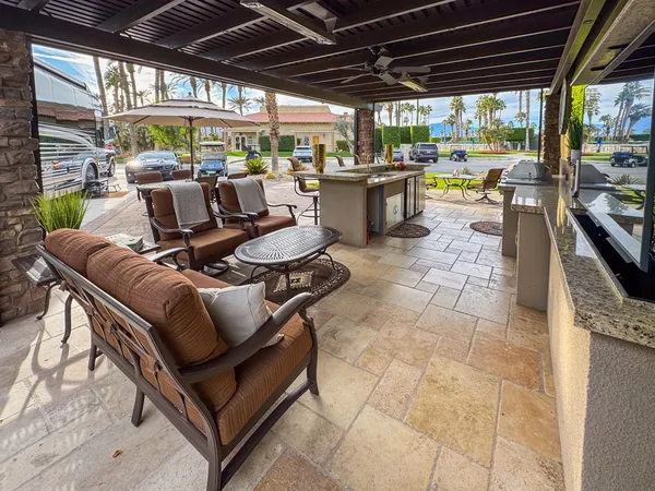 a view of a chairs and table in patio with a barbeque grill