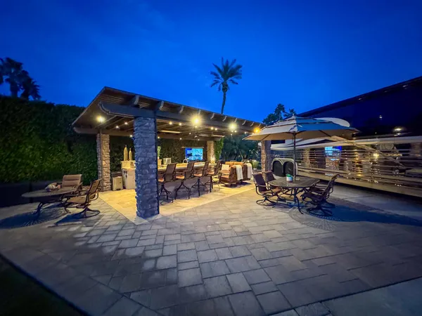a view of a patio with table and chairs under an umbrella