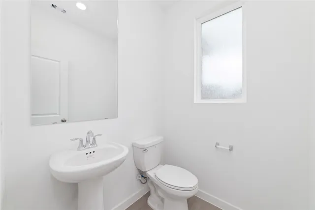 a bathroom with a sink a toilet and mirror