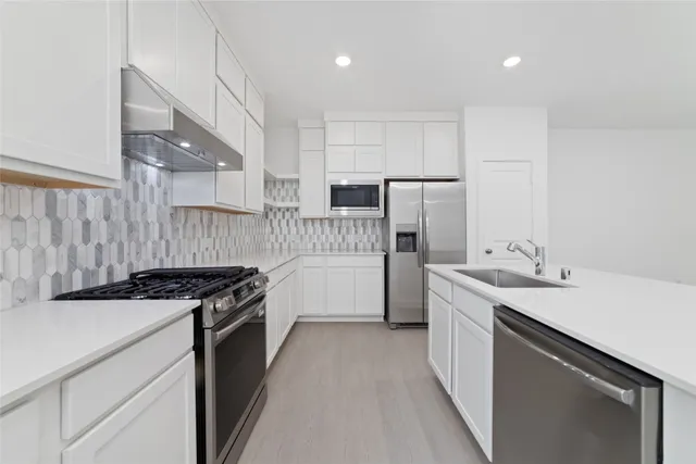 a kitchen with a sink stove and refrigerator