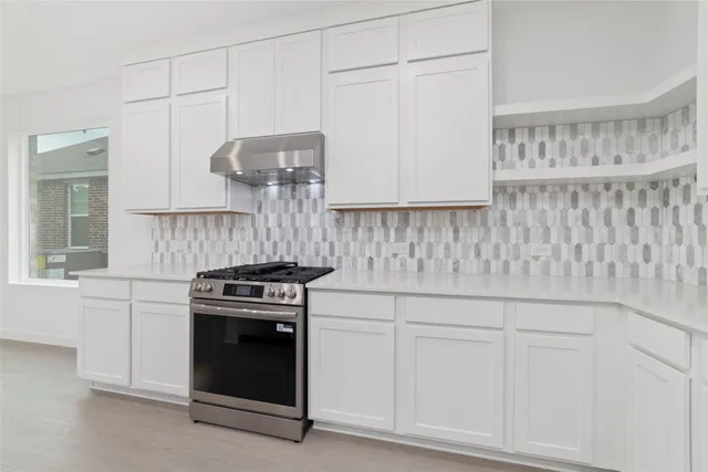 a kitchen with granite countertop white cabinets and stainless steel appliances