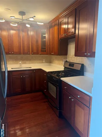a large kitchen with granite countertop a stove and a sink