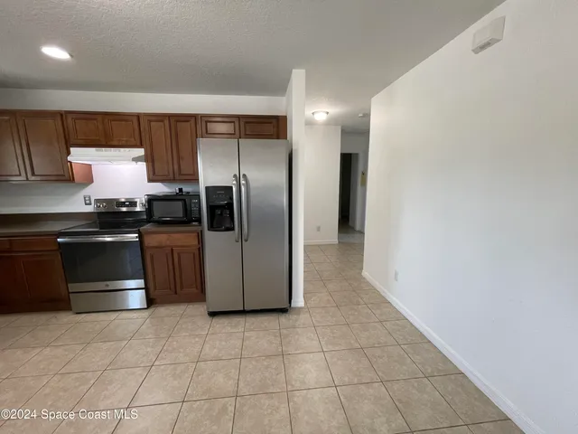 a kitchen with stainless steel appliances granite countertop a stove a refrigerator and a sink