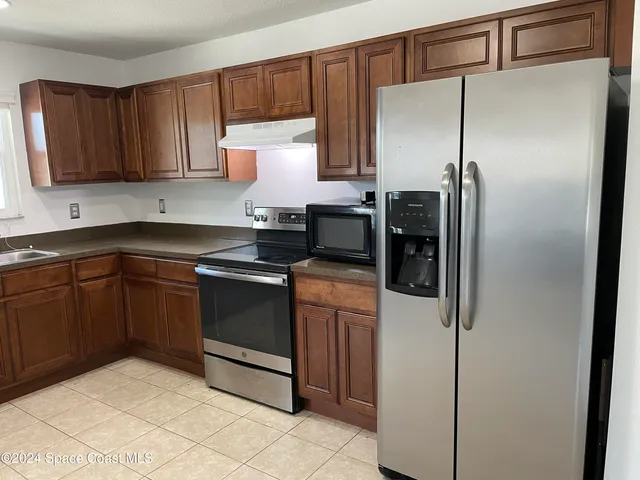 a kitchen with a refrigerator sink and cabinets