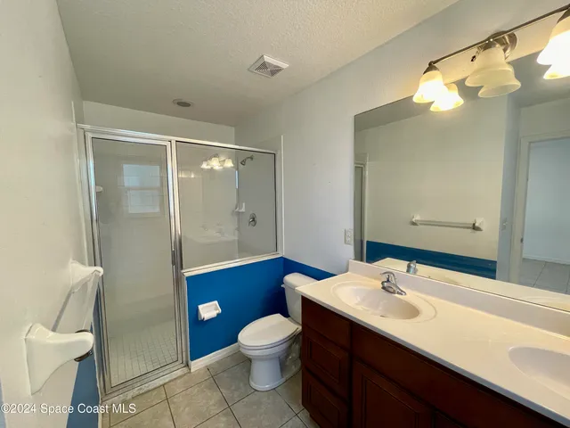 a bathroom with a sink a toilet a mirror and shower