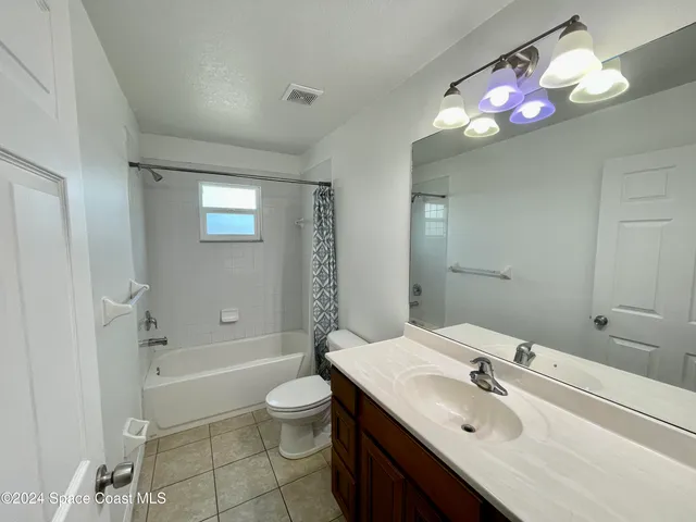 a bathroom with a sink vanity tub and toilet