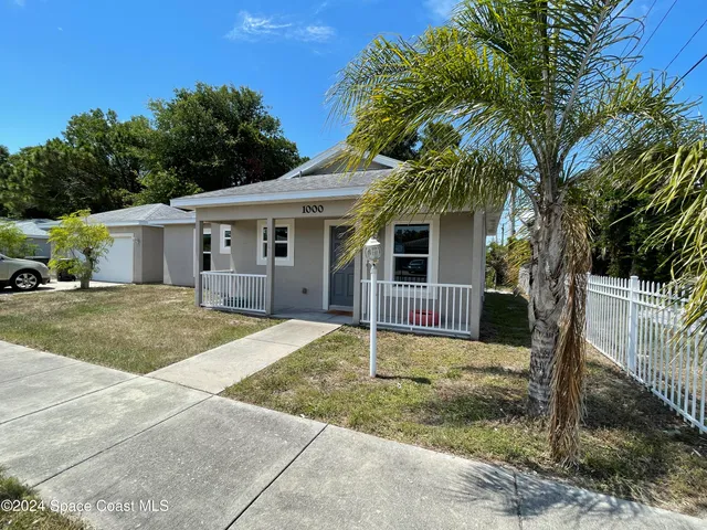 a front view of house with yard and trees around