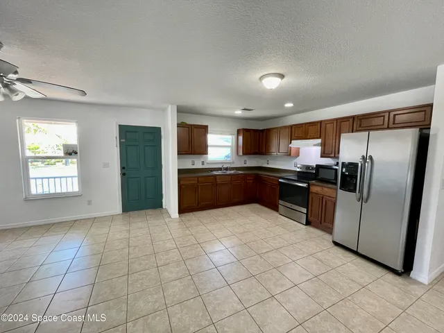 a large kitchen with stainless steel appliances granite countertop a refrigerator and a stove top oven