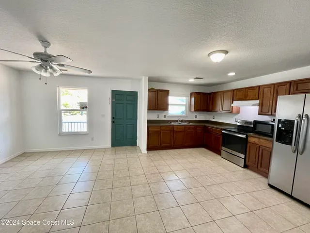 a large kitchen with a stove a sink dishwasher and a refrigerator