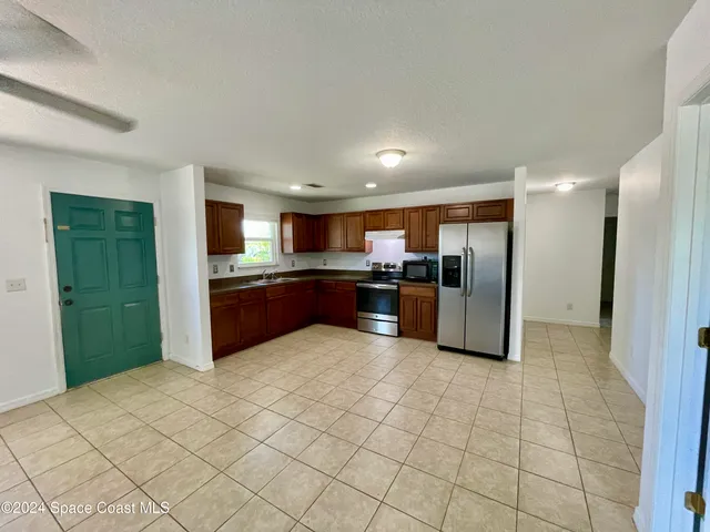 a large kitchen with cabinets and stainless steel appliances