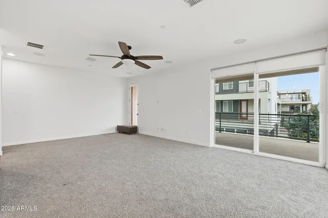 a view of a room with a ceiling fan and window