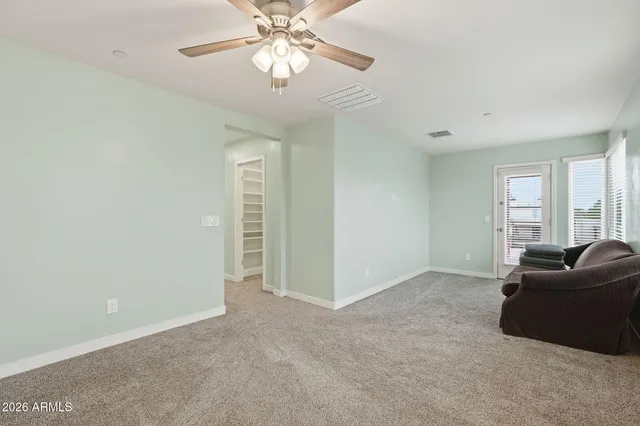 a living room with furniture and a ceiling fan