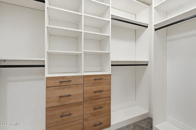 a view of walk in closet with empty racks