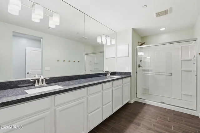 a bathroom with double vanity and a mirror