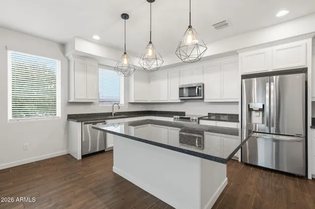 a kitchen with stainless steel appliances granite countertop a stove a refrigerator and a sink