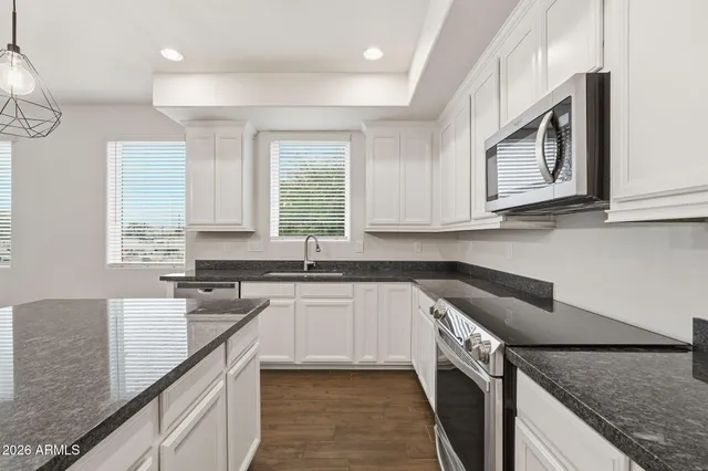 a kitchen with stainless steel appliances granite countertop a sink stove and cabinets