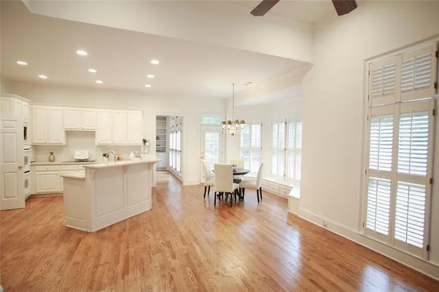 a large white kitchen with lots of counter top space and stainless steel appliances
