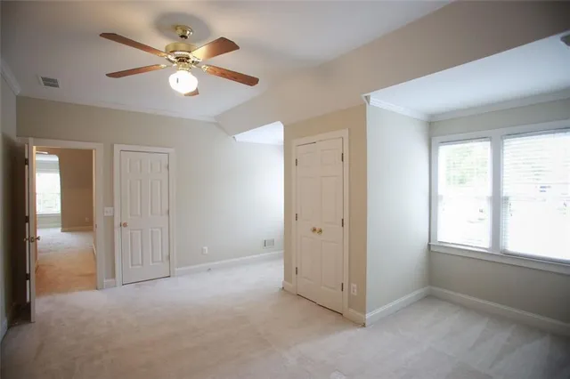 an empty room with windows and fan