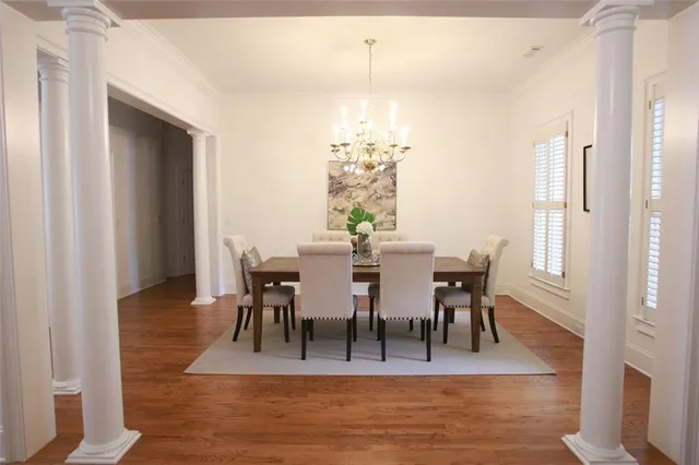 a view of a dining room with furniture a chandelier and wooden floor