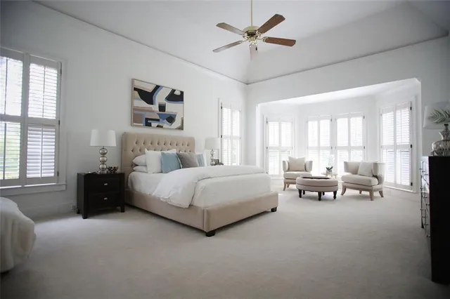 a spacious bedroom with a bed a couch and a large window