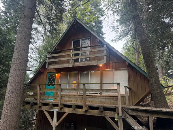 a view of house with wooden stairs and large trees