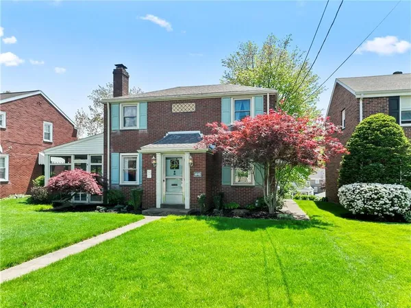 a front view of a house with a garden