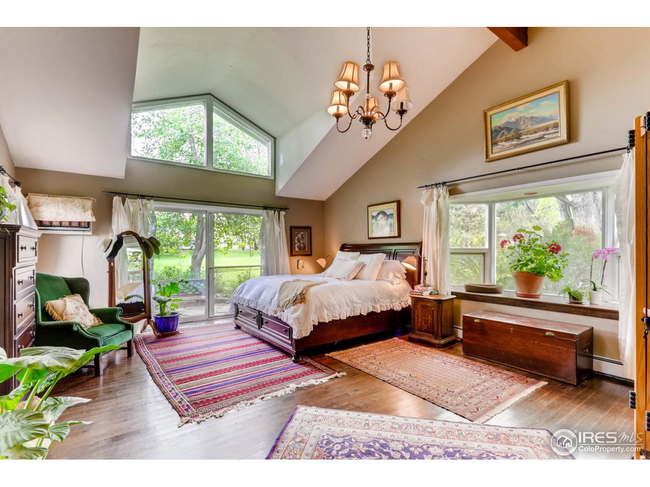 9760 Isabelle Road Lafayette, CO 80026 - Photo 12 of 40 a spacious bedroom with a large bed and a chandelier
