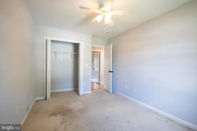 an empty room with a ceiling fan and a window