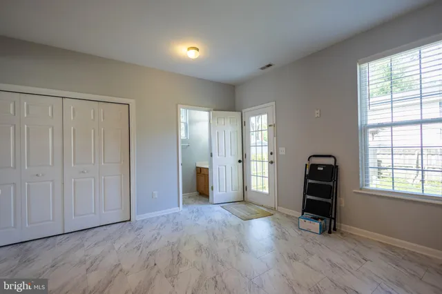 an empty room with windows and closet