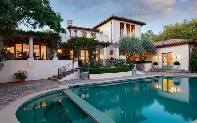 a front view of a house with swimming pool having outdoor seating