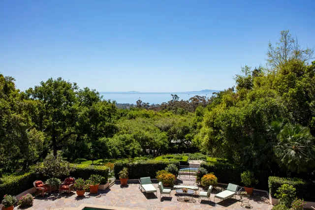 a view of a patio with furniture and a garden